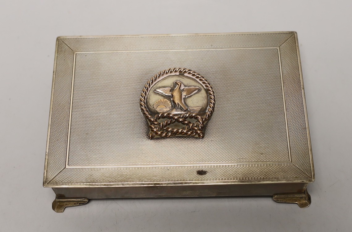 An Elizabeth II engine turned silver rectangular cigarette box, with yellow metal applique and interior inscription relating to the Hong Kong Rope Manufacturing Co, 17.4cm.